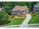 Aerial view of a brick home surrounded by lush greenery, showcasing its spacious lot and neighborhood at 255 Beech Tree Holw, Sugar Hill, GA 30518