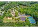 An aerial shot of a community clubhouse, pool, tennis courts, and play areas surrounded by lush greenery and trees at 255 Beech Tree Holw, Sugar Hill, GA 30518