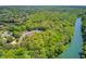 Aerial view of a community with a river, highlighting lush green trees, a community center, tennis courts, and a tranquil lake at 255 Beech Tree Holw, Sugar Hill, GA 30518