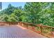 Spacious wooden back deck with decorative railings and wooded surroundings provides private outdoor living at 255 Beech Tree Holw, Sugar Hill, GA 30518