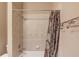 Tiled shower-tub combination with a patterned shower curtain and silver fixtures and hardware at 255 Beech Tree Holw, Sugar Hill, GA 30518