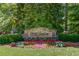 Stone entrance to Wild Timber with colorful flower bed at 255 Beech Tree Holw, Sugar Hill, GA 30518