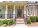 Close-up of a home's entrance with decorative wood door, stone accents, and manicured shrubs at 255 Beech Tree Holw, Sugar Hill, GA 30518