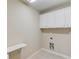 Efficient laundry room features white cabinets, utility sink, and tile flooring at 255 Beech Tree Holw, Sugar Hill, GA 30518