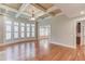 Spacious living room featuring hardwood floors, coffered ceilings, and large windows providing natural light at 255 Beech Tree Holw, Sugar Hill, GA 30518