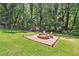 Lush backyard featuring a fire pit and playground, creating a perfect outdoor space for relaxation and recreation at 3248 Wildwood Sw Dr, Marietta, GA 30060
