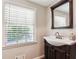 Charming bathroom featuring a window with blinds, vanity, and decorative mirror for a bright and classic look at 3248 Wildwood Sw Dr, Marietta, GA 30060