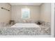 Luxurious bathroom featuring a large soaking tub with decorative tile surround and updated fixtures at 3248 Wildwood Sw Dr, Marietta, GA 30060