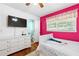 Stylish bedroom boasting hardwood floors, and modern media capabilities with pink accent wall at 3248 Wildwood Sw Dr, Marietta, GA 30060