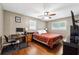 Comfortable bedroom with hardwood floors, a ceiling fan, and natural light from two windows at 3248 Wildwood Sw Dr, Marietta, GA 30060