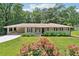 Charming single-story home featuring a covered carport, manicured lawn, and blooming flower beds at 3248 Wildwood Sw Dr, Marietta, GA 30060