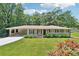 Charming single-story home featuring a covered carport, manicured lawn, and blooming flower beds at 3248 Wildwood Sw Dr, Marietta, GA 30060