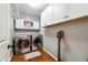 Well-organized laundry room with modern washer and dryer, upper cabinets, and a convenient vacuum cleaner at 3248 Wildwood Sw Dr, Marietta, GA 30060