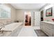 Well-lit main bathroom featuring a tub, walk-in closet, double door access, and a granite-topped vanity at 3248 Wildwood Sw Dr, Marietta, GA 30060