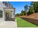 Landscaped backyard featuring a retaining wall, green grass, and a covered patio with modern seating at 4011 Fallen Leaf Ct, Kennesaw, GA 30152