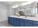 Stylish bathroom featuring a double vanity with blue cabinetry and white countertop, plus large mirror and modern fixtures at 4011 Fallen Leaf Ct, Kennesaw, GA 30152