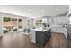 Modern kitchen with white cabinets, gray island, stainless steel appliances and an adjacent dining area at 4011 Fallen Leaf Ct, Kennesaw, GA 30152