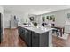 Open-concept kitchen showcasing gray cabinets, stainless steel appliances, and seamless flow to the living area at 4011 Fallen Leaf Ct, Kennesaw, GA 30152