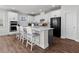 Modern kitchen with white cabinets, gray island, stainless steel appliances, and a breakfast bar at 4011 Fallen Leaf Ct, Kennesaw, GA 30152