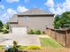 Side view of a house featuring a two-car garage and a fenced backyard at 5220 Southern Hills Ln, Cumming, GA 30040