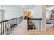 Upstairs hallway featuring iron railing and view into multiple rooms at 5220 Southern Hills Ln, Cumming, GA 30040
