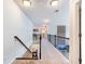 Bright upstairs hallway with carpet, railing, and view of living space below at 5220 Southern Hills Ln, Cumming, GA 30040