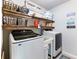 Well-organized laundry room with modern appliances, wooden shelves, and functional decor at 5220 Southern Hills Ln, Cumming, GA 30040