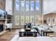 Living room with stone fireplace and tall windows providing ample natural light at 5220 Southern Hills Ln, Cumming, GA 30040