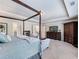 Bright main bedroom showcasing a four-poster bed, dresser, and adjacent en-suite bathroom at 5220 Southern Hills Ln, Cumming, GA 30040