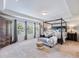 Spacious main bedroom featuring a four-poster bed, sitting area, and large windows with natural light at 5220 Southern Hills Ln, Cumming, GA 30040