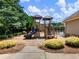 Community playground with climbing structure, slide, benches, and natural landscaping elements at 5220 Southern Hills Ln, Cumming, GA 30040