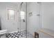 Bright bathroom with a glass shower, patterned floors, and window at 6090 Heritage Se Way, Mableton, GA 30126