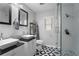 Modern bathroom features double vanity sinks, patterned tile flooring, and glass enclosed shower at 6090 Heritage Se Way, Mableton, GA 30126