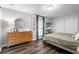 Comfortable bedroom features natural light, wood flooring, a spacious closet, and stylish furnishings at 6090 Heritage Se Way, Mableton, GA 30126
