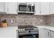 Close up of the kitchen area featuring stainless steel oven, tile backsplash, and quartz countertops at 6090 Heritage Se Way, Mableton, GA 30126