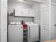 Functional laundry room features matching washer and dryer units, storage cabinets, and ample space at 6090 Heritage Se Way, Mableton, GA 30126