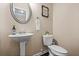 Stylish powder room featuring a pedestal sink, decorative mirror, and modern fixtures, perfect for guests at 881 Ash St, Canton, GA 30114