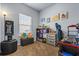 Well-lit bedroom with plush carpet, showcasing a cozy window, playful decor, and ample shelving for storage at 881 Ash St, Canton, GA 30114