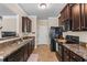 Bright kitchen featuring stainless steel appliances, dark wood cabinetry, and tile flooring at 881 Ash St, Canton, GA 30114