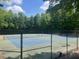 Fenced tennis courts are surrounded by mature trees providing shade at 881 Ash St, Canton, GA 30114