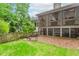 Backyard view featuring a screened deck, wooden fence, and gravel bed at 1205 Rivershyre Ne Pkwy, Lawrenceville, GA 30043