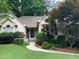 Charming single-story home featuring lush landscaping and a welcoming front entrance with a stone walkway at 1205 Rivershyre Ne Pkwy, Lawrenceville, GA 30043