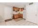 Functional kitchenette with wooden cabinets, a white refrigerator, and a tile floor at 1205 Rivershyre Ne Pkwy, Lawrenceville, GA 30043