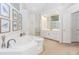 Bathroom features a large tub with tile surround, walk-in shower, and vanity with lots of drawers at 1205 Rivershyre Ne Pkwy, Lawrenceville, GA 30043
