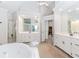 Spacious bathroom with a large tub, shower, white vanity, and bright lighting at 1205 Rivershyre Ne Pkwy, Lawrenceville, GA 30043