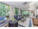 Relaxing sun room with a ceiling fan, views of the wooded backyard, and comfortable seating at 1205 Rivershyre Ne Pkwy, Lawrenceville, GA 30043