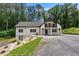 Charming two-story white home with a balcony, lovely landscaping, and a spacious driveway surrounded by mature trees at 1887 Shalimar Dr, Atlanta, GA 30345