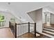 Bright hallway with hardwood floors, modern railing, and natural light streaming through a nearby glass paned door at 1887 Shalimar Dr, Atlanta, GA 30345