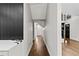 Well-lit hallway with hardwood floors, a modern accent wall, and a view into the living spaces at 1887 Shalimar Dr, Atlanta, GA 30345