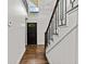 Hallway featuring hardwood floors, modern black railings and white walls leading to an entryway door with glass at 1887 Shalimar Dr, Atlanta, GA 30345